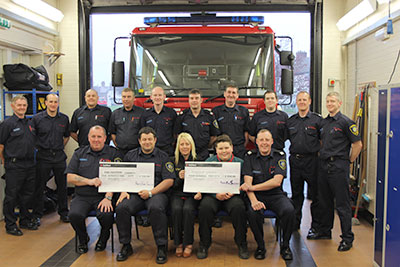 Group shot in appliance bay in front of fire appliance