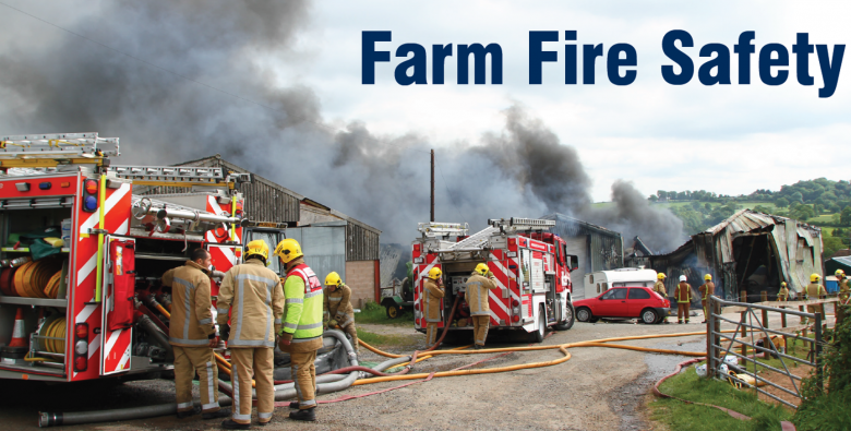 A country lane with fire engines parked and fire and smoke from a barn on fire beyond