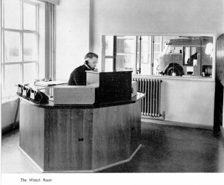 The old Watch Room at Wellington Fire Station with its new console control room with a 1950s fire engine in the bay.